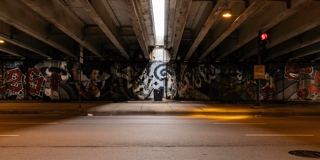 Nighttime mural-covered city underpass from the Too Low visual world
